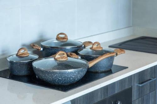 a group of pots and pans sitting on a stove at Cosy 2 Bed at Embassy Gardens in Cantonments