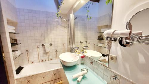 a bathroom with two sinks and a tub at Entre Dos Aguas Hotel Boutique in Toledo
