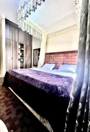 1 dormitorio con 1 cama grande con sábanas moradas en Inviting 1-Bed Apartment in Kampala, en Jinja