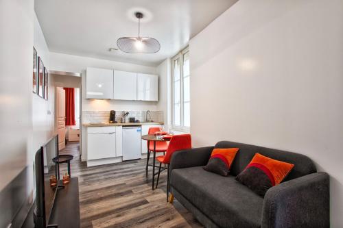 un salon avec un canapé et une cuisine dans l'établissement Le Havre - Quartier des Docks au Calme - Appartement T3 Entièrement Rénové, au Havre