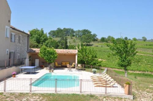 une piscine dans une cour à côté d'une maison dans l'établissement La Grange, à Saint-Sauveur-de-Cruzières