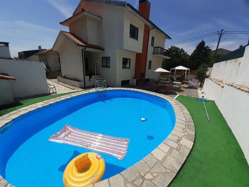 a swimming pool in front of a house at Morada do Ultramar in Viana do Castelo