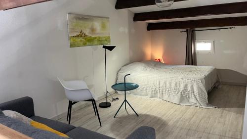 sypialnia z łóżkiem, krzesłem i kanapą w obiekcie Appartement - Résidence Le Paradou w mieście Rayol-Canadel-sur-Mer