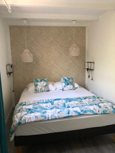 - une chambre dotée d'un grand lit avec des draps bleus et blancs dans l'établissement 2 pièces indépendant avec son jardinet privé, à Borgo