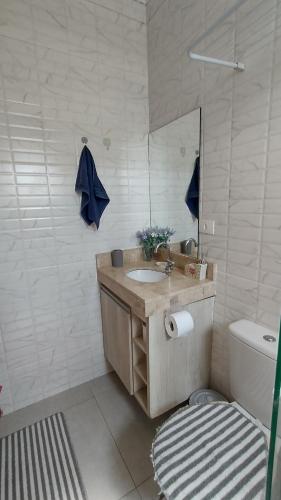 a bathroom with a sink and a toilet and a mirror at Flat Getsêmani Olímpia a 10min do Thermas dos Laranjais in Olímpia