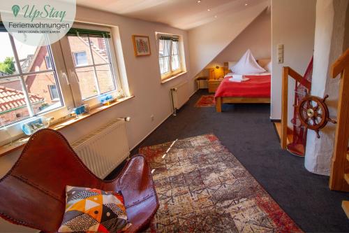 um quarto com uma cama e uma cadeira num quarto em Manslagter Diekkieker em Krummhörn