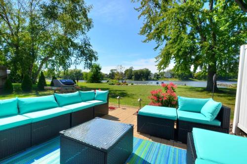 a patio with blue couches and a view of a park at Riverfront Retreat! Water front and dog friendly! in Two Rivers