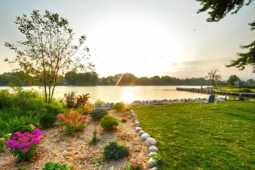 a garden with flowers next to a body of water at Riverfront Retreat! Water front and dog friendly! in Two Rivers