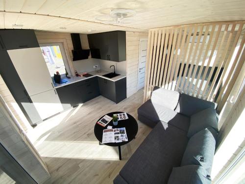 uma sala de estar com um sofá e uma mesa em Tiny house aan het water op de appelhof em Wommels