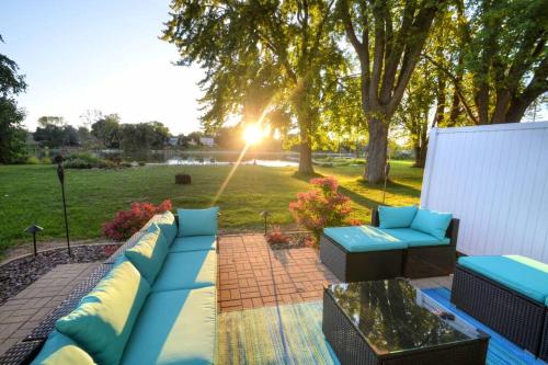 a backyard patio with blue couches and a lawn at Riverfront Retreat! Water front and dog friendly! in Two Rivers