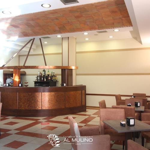 a restaurant with a counter and tables and chairs at Hotel Ristorante Al Mulino by LVG Hotel Collection in Alessandria