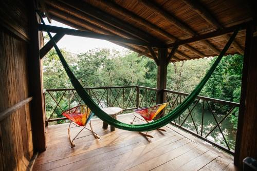 two chairs sitting in a hammock on a porch at La Martina Ecolodge in Nuquí