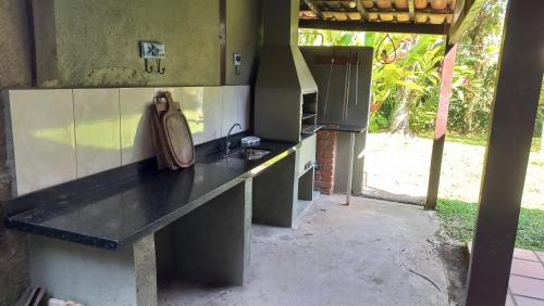 eine Außenküche mit einer Theke und einer Spüle in der Unterkunft Casa Rústica Alemã - 50m da praia in Ubatuba