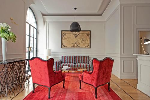 a living room filled with furniture and a red wall at The Fifteen Keys Hotel in Rome