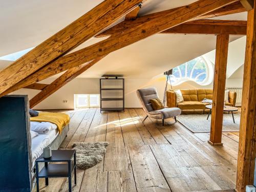 um quarto no sótão com uma cama e uma cadeira em Loft-Wohnung im Herzen von Prien - 100m2 - SmartTV em Prien am Chiemsee