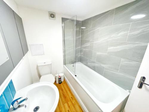 a bathroom with a sink and a tub and a toilet at Prime Woolwich 2 Bed Gem in Woolwich