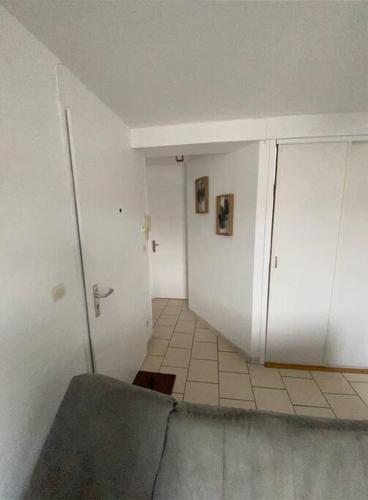 Habitación con pasillo con puerta y suelo de baldosa. en Appartement F2 hyper centre, en Lacroix-Saint-Ouen