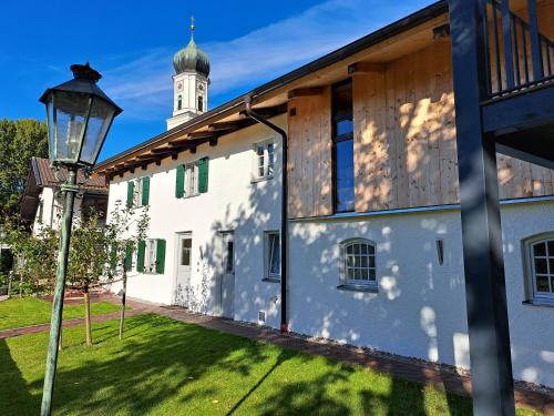 ein Gebäude mit Straßenbeleuchtung und Turm in der Unterkunft Neu! Ferienwohnungen im Lüftlmalereck, Hennalahaus in Oberammergau