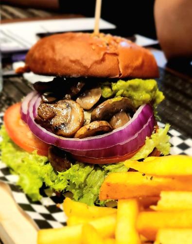 a hamburger with mushrooms and vegetables on a plate at ibis Santiago Estacion Central in Santiago