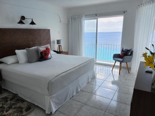 ein Schlafzimmer mit Bett und Blick auf das Meer in der Unterkunft Coral Princess Hotel & Dive Resort in Cozumel