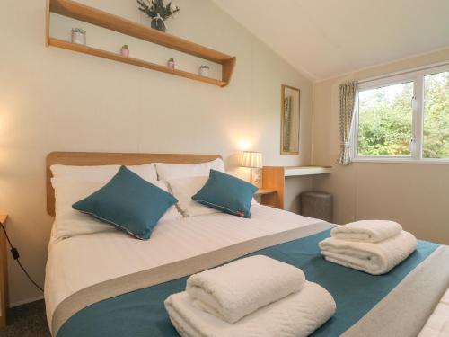 um quarto com uma cama com almofadas azuis e brancas em 12 Meadow View em Carnforth