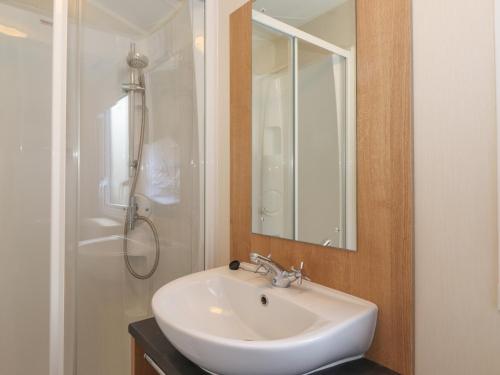 uma casa de banho com um lavatório branco e um chuveiro em 12 Meadow View em Carnforth