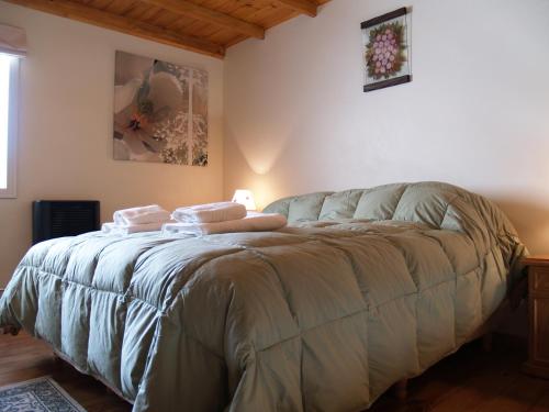 1 dormitorio con 1 cama con 2 toallas en Esquel Apart Loft en Esquel