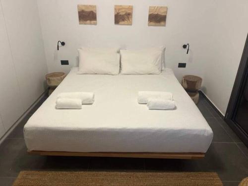 1 cama blanca grande con 2 toallas en Ek Ornelakis, Luxury Country House with Jacuzzi, en La Canea