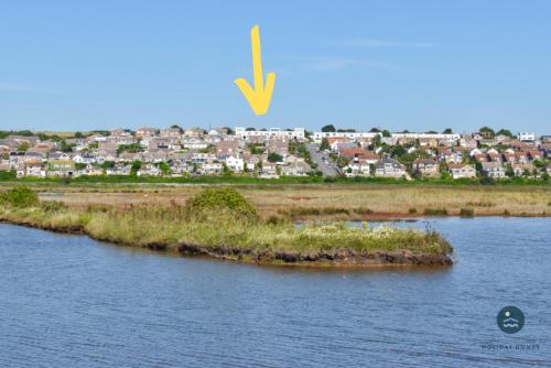 an island in the water with a city in the background at Pebble House - Sea views parking family friendly in Weymouth