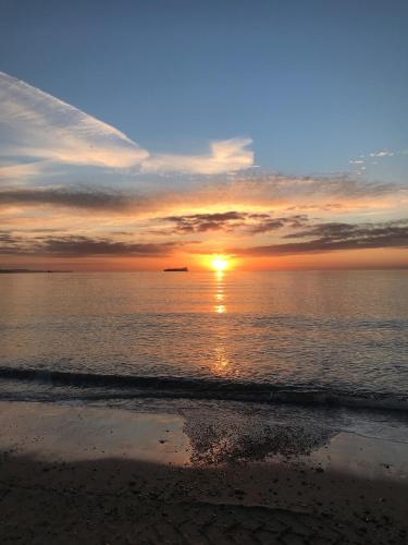 a sunset on a beach with the ocean at Pebble House - Sea views parking family friendly in Weymouth