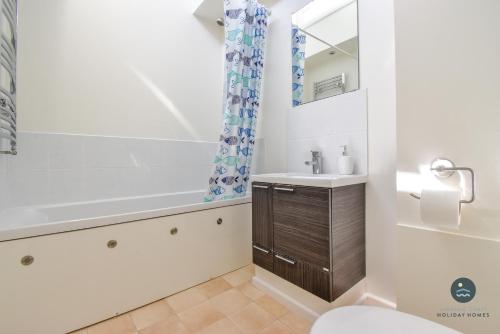 a bathroom with a sink and a tub and a toilet at Pebble House - Sea views parking family friendly in Weymouth