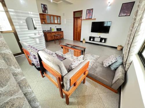 een woonkamer met een bank en een tv bij Success Apartment - Diamond in Mwanza