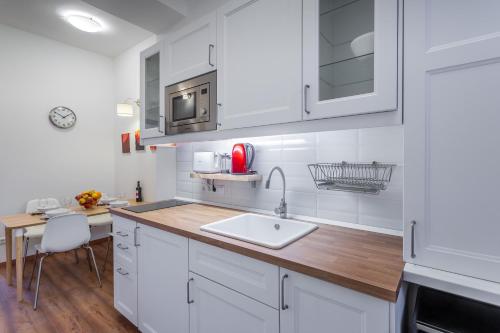 a kitchen with white cabinets and a sink at Central Avenue Apartment in Budapest