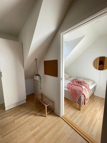 a bedroom with a mirror and a bed in a attic at Ophold i hjertet af Odense! in Odense