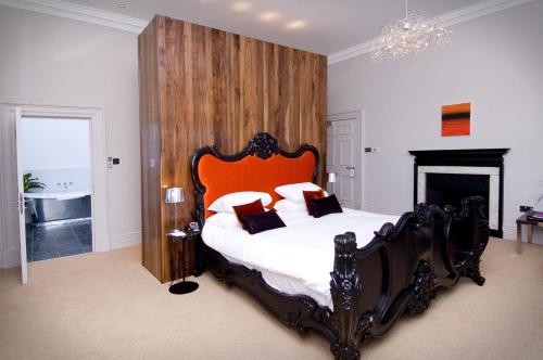 a bedroom with a large bed with an orange headboard at Aston Hall Hotel, BW Signature Collection in Sheffield