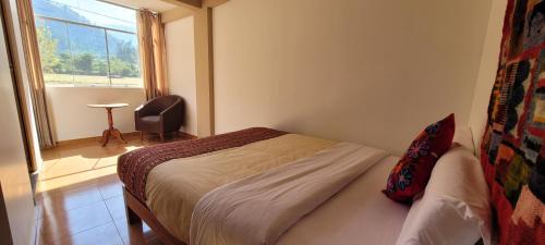 a small bedroom with a bed and a window at Ayllu B&B Ollantaytambo in Ollantaytambo