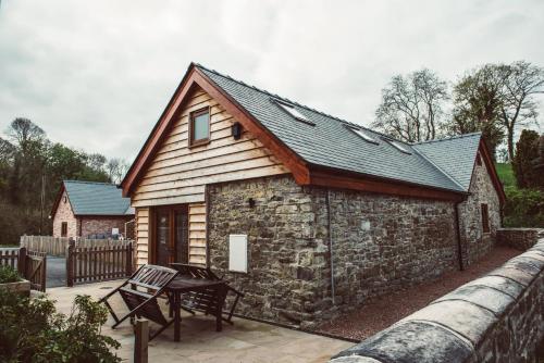 a small cabin with a slate roof and a patio at The Granary in Montgomery