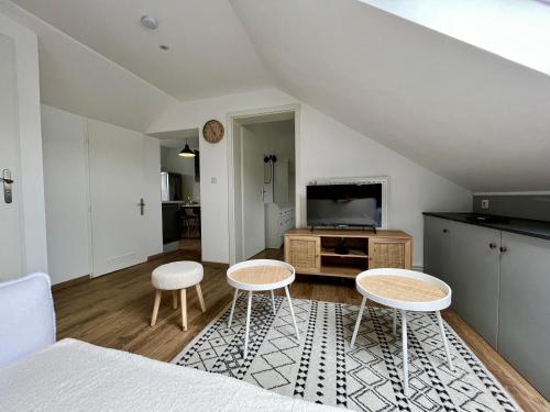 un salon avec deux chaises et une télévision dans l'établissement Charmant Apt White&Grey 3BR Proche Centre et Gare, à Thionville