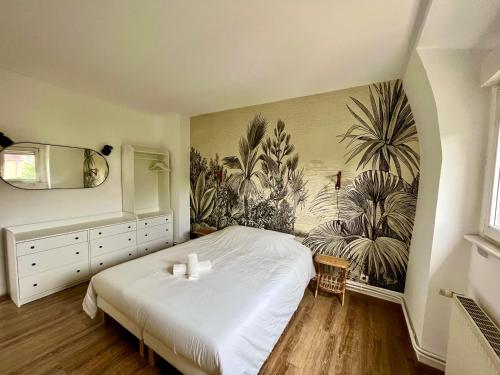 蒂永維勒的住宿－Charmant Apt White&Grey 3BR Proche Centre et Gare，卧室配有一张床,墙上挂有绘画作品