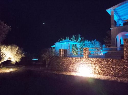 a stone wall with blue lights in front of a building at Villa Katia in Tsoukaladhes