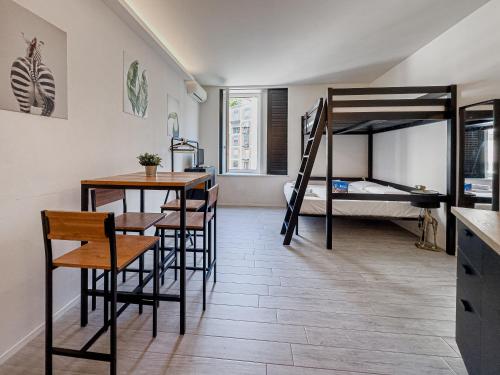 Cette chambre comprend des lits superposés, une table et des chaises. dans l'établissement Realkasa Marconi, à Bologne