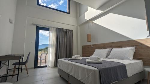 a bedroom with a bed and a desk and a window at Costa Ionica · Mytikas Seaside Hotel in Mýtikas
