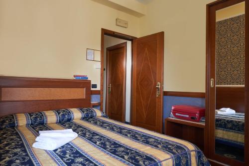 a hotel room with two beds and a door at Hotel Ristorante La Piana in Telese