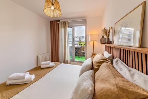 Un dormitorio con una gran cama blanca y una ventana en Le Dobrée - Centre - Charme & Confort - 4p - 55m2 en Nantes