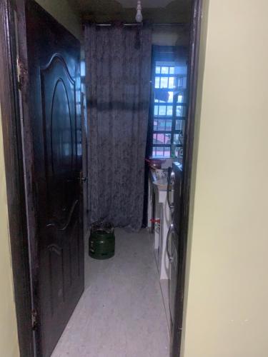 um corredor com uma porta que leva a um quarto com um lavatório em Nyumbani kuzuri em Nakuru