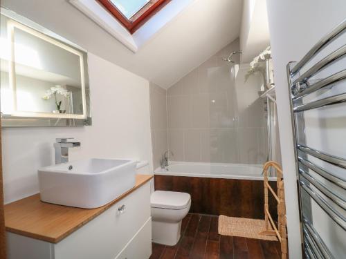 a bathroom with a sink and a toilet and a bath tub at The Old Bakehouse in Oakham