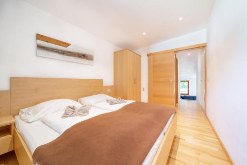 a bedroom with a large bed with white sheets at am mühlbach - einfach sein, mit Gemeinschaftsküche in Dorfgastein