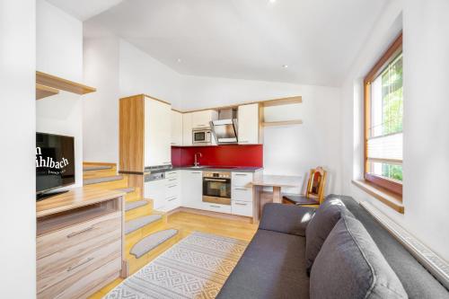 a living room with a couch and a kitchen at am mühlbach - einfach sein, mit Gemeinschaftsküche in Dorfgastein
