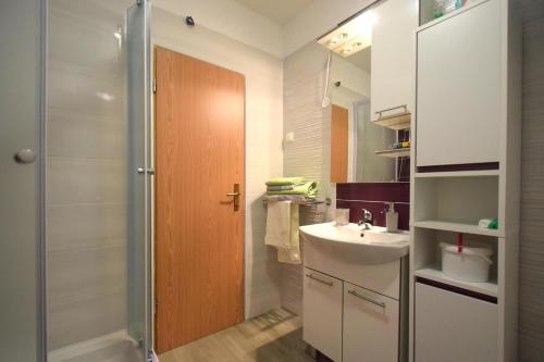 a small bathroom with a sink and a shower at Apartments Cindric in Malinska