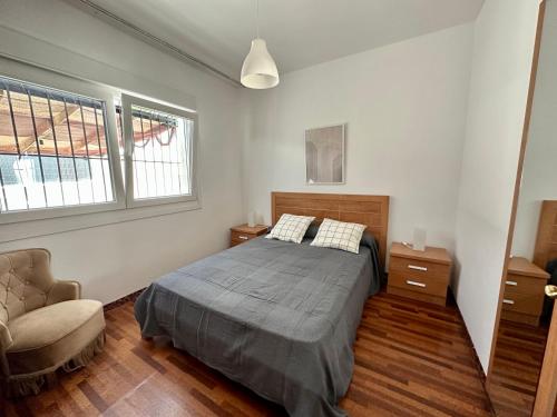 1 dormitorio con 1 cama y 1 silla en CasaLola - Corme Porto, en A Coruña